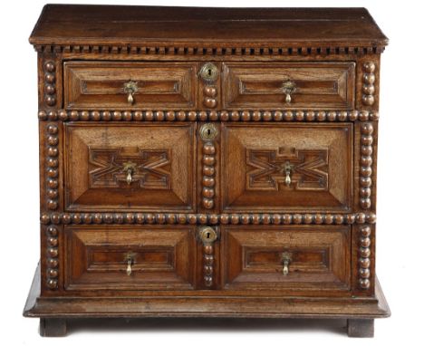 A WILLIAM AND MARY OAK CHEST C.1690 the top with a moulded edge, above three long drawers with geometric moulded fronts, with