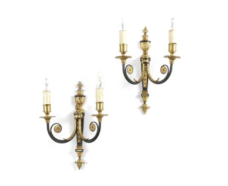 A SET OF FOUR GILT BRASS AND EBONISED TWIN-LIGHT WALL LIGHTS IN 18TH CENTURY STYLE each with a flaming urn backplate and leaf