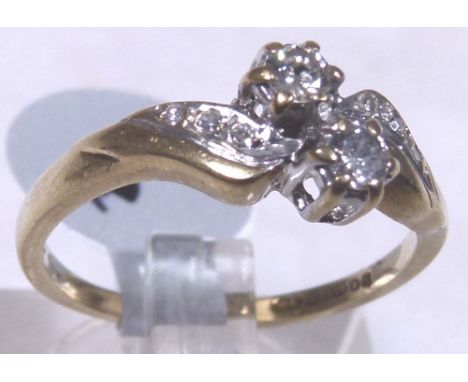 DIAMOND TWIST RING. 9 ct gold two stone set diamond ring on a twist, approximately 0,25ct, size K