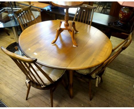 A good quality Ercol medium elm dining suite, comprising drop leaf dining table and four spindle back chairs.