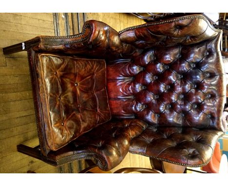 A fine quality reproduction Regency style gentleman's wingback armchair upholstered in a maroon button back material.