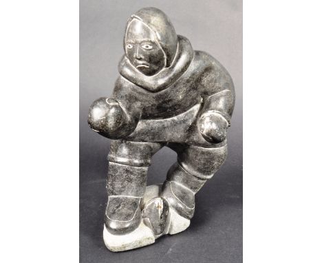 David Irqu Irqumia - A large Inuit art hand carved polished shiny black stone figurine depicting a male figure Inuit fisherma