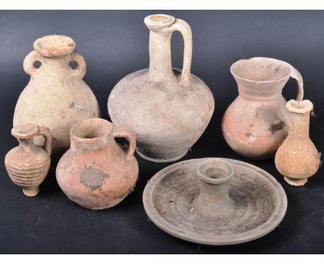 A collection of seven pieces of Ancient Roman pottery to include candlestick on large circular plate base, large single handl