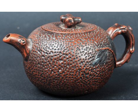 An early 20th Century Chinese Yixing / Yi-Xing terracotta red clay pottery teapot. The teapot having an orange peel texture w