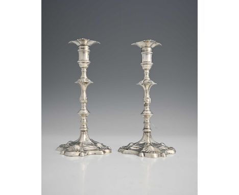 A pair of early George III silver cast candlesticks, each with a baluster knop stem, atop a panelled and stepped square base 