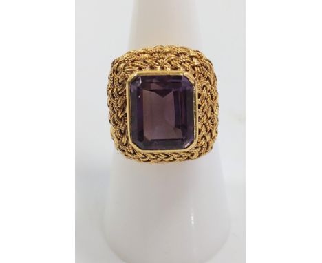 An 18ct gold ring set with a purple stone. Size K 