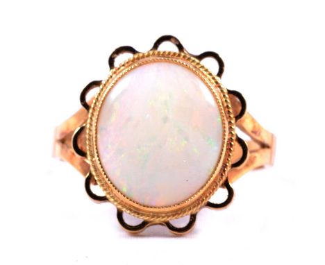 An opal dress ring, the approximately 13.3x11.5mm cabochon cut opal collet set with a rope border and outer petal surround in