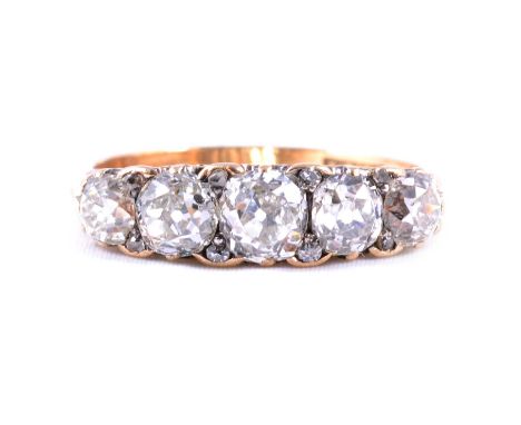 A diamond five stone half hoop ring, the old cut stones graduating in size claw set in an all yellow metal carved claw mount 