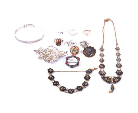 A collection of silver and white metal rings, bangle, brooches and costume jewellery, a tiger's eye ring, the cabochon cut ti