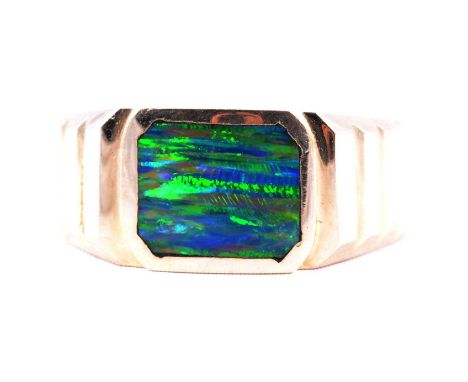 A yellow metal signet style ring set with an opal coloured stone, ring size T, the rectangular stone set in a closed back set