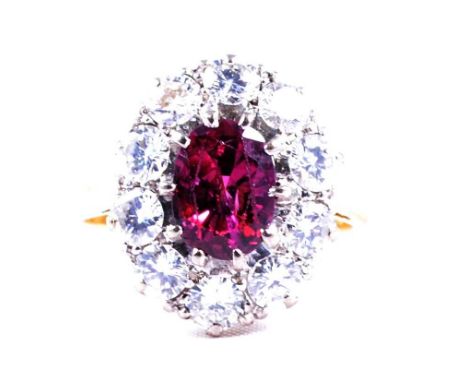 A ruby and diamond oval cluster ring, an oval mixed cut ruby, 7.8x5.8mm, claw set and surrounded by ten brilliant cut diamond