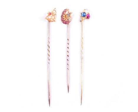 Three stick/tie pins in a vintage box, a 10mm butterfly marked 15c set with seed pearls and a small ruby; a closed crescent p