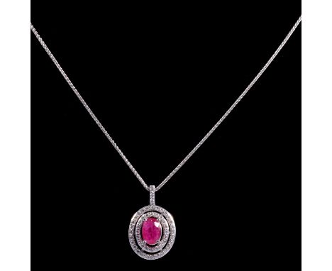 A ruby and diamond pendant on a white metal chain, the oval mixed cut ruby, 6.9x4.8mm, within an openwork double surround of 