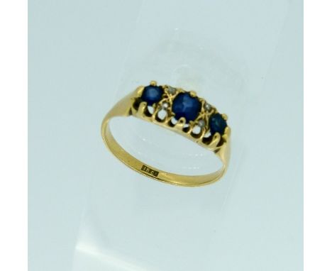 A three stone sapphire and diamond Ring, the oval facetted sapphires with two small diamonds between, all mounted in 18ct yel