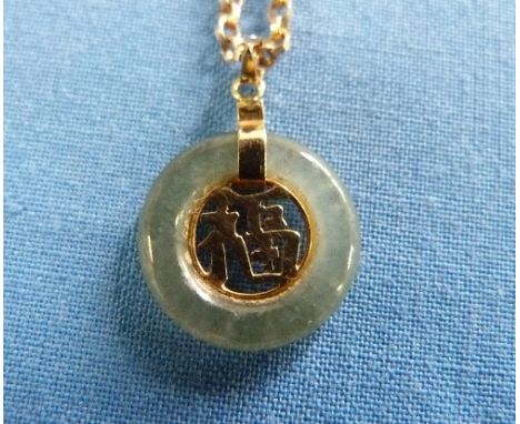 A small circular Jade Pendant, the centre set with cut out Old Chinese characters, suspended from a gold loop marked 14k and 