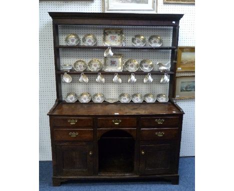 A Georgian oak Dresser, the open plate rack set on a base with rectangular top above five drawers and two cupboard doors with