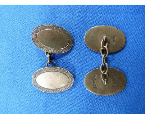 A pair of 9ct yellow gold oval Cufflinks, with chain between, the fronts with engine turned borders, plain centres, each mark
