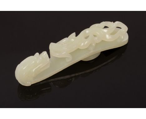 A Chinese white jade carved belt hook, Qing, in the form of a dragon, 12cm long CONDITION REPORT: Condition information is no
