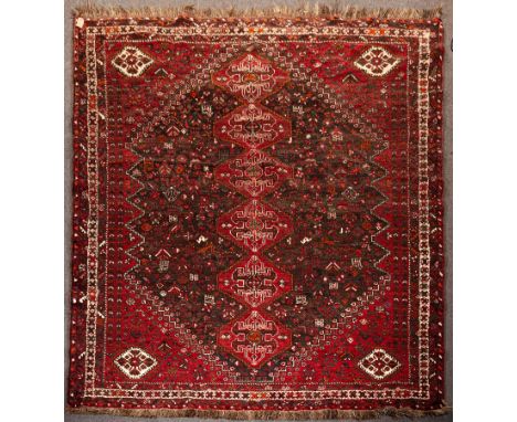 A Shiraz carpet, South West Persia, late 20th Century, the charcoal field of raspberry red turtle design pole medallions fram