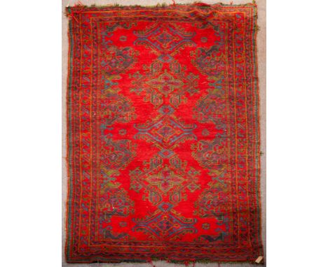 An Ushak Gallery carpet, West Anatolia, circa 1920, the tomato red field of open lozenge medallions and palmettes framed by a