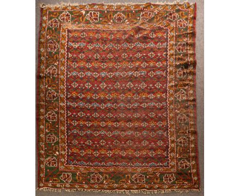 An Indian carpet, mid 20th Century, the sang du boeuf lattice design fields framed by a forest green border of scrolling vine