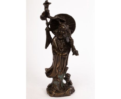 A Chinese bronze statue, 19/20th Century, depicting the Buddhist monk Bodhidharma (Damo), carrying a tree branch with a hulu 