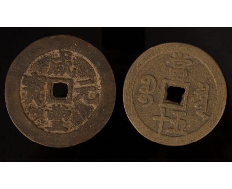Two Chinese bronze coins, the larger coin reads as 'Xianfeng Yuanbao' (Treasure of Emperor Xianfeng [1850 - 1861]) to one sid
