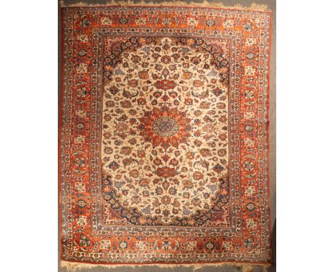 An Isfahan carpet, Central Persia, mid 20th Century, the ivory field centred by a madder medallion with indigo spandrels and 