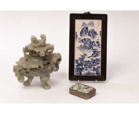 A Chinese carved stone censer decorated with dragons and Foo dogs, 23.5 high, a blue and white porcelain plaque depicting a c