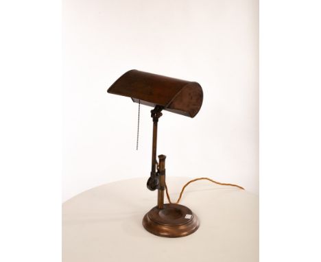 A copper finished metal desk lamp, with articulated shade, height and angle adjustable arm on dish moulded base, impressed GE