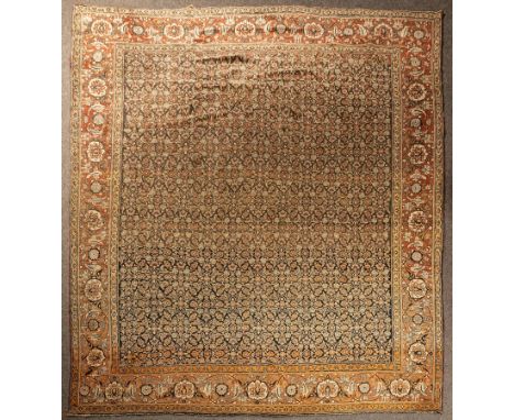 A Tabriz carpet, North West Persia, circa 1900, the abrashed indigo/charcoal field with an all over herati design, framed by 