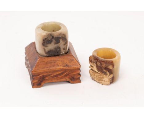 Two Chinese archer's rings, Qing Dynasty, one celadon jade with the relief of Longhudou depicting a dragon fighting a tiger, 