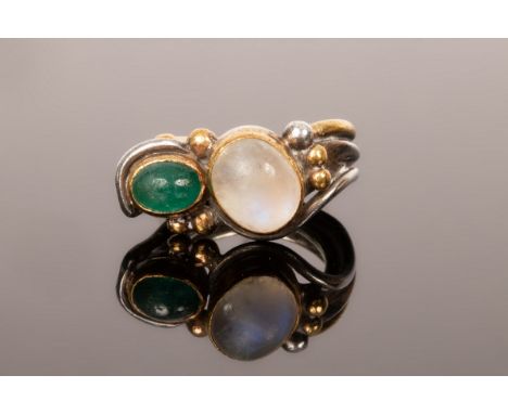 A silver ring by Barbara Bertagnolli with cabochon set oval moonstone and tourmaline, within an overlapping bi-colour setting
