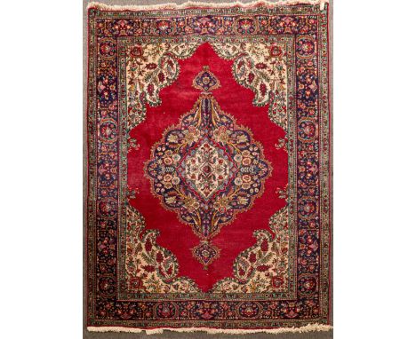 A Tabriz carpet, North West Persia, the burgundy field with an indigo pendant medallion and indigo borders, 295cm x 204cm CON