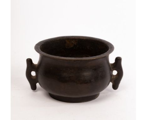 A Chinese bronze scholar's incense burner, Qing, the compressed circular body raised on a short straight foot, cast with two 
