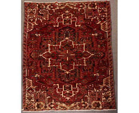 A Heriz carpet, North West Persia, the strawberry red field centred by an indigo medallion and framed by ivory spandrels (lac