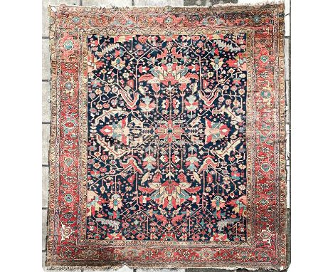 A Heriz carpet, North West Persia, circa 1900, the indigo field with an all over design of flowering vines and serrated leave