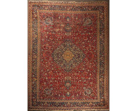 A Tabriz carpet, North West Persia, the madder field with an indigo medallion, indigo palmette border and mustard guard strip