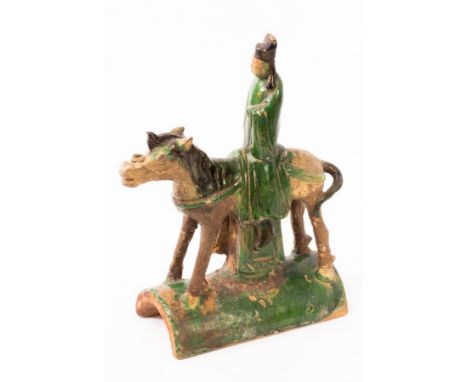 A Chinese green glazed ceramic ridge tile, Ming dynasty, with an official riding a horse, 32.5cm high CONDITION REPORT: Condi