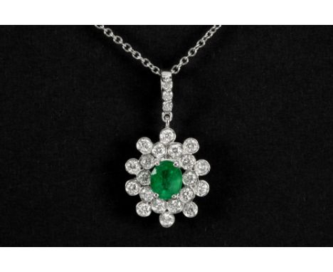 refined pendant in white gold (18 carat) with a ca 0,70 carat Colombian emerald with a nice color, surrounded by ca 0,95 cara