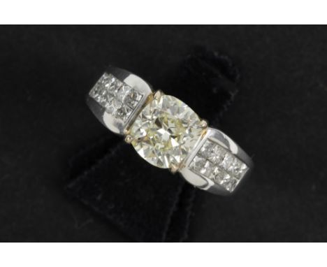 a 1,76 carat light fancy yellow quality cushion cut diamond set in yellow gold (18 carat) on a ring in white gold (18 carat) 