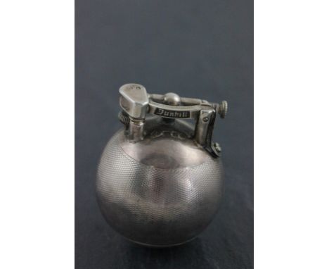 A hallmarked silver Dunhill lighter; of spherical form; with engine turned decoration; the hinged arm detailed Dunhill; Alfre