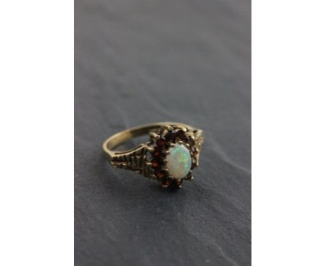 An opal and ruby cluster ring; set on a 9ct yellow gold band