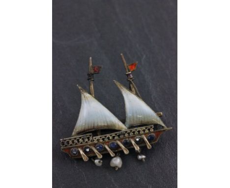 An enamel and silver bar brooch; set with sapphires; in the form of a long boat