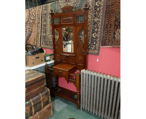 An early 20th century mahogany mirror backed hallstand with twin stick wells and central drawer