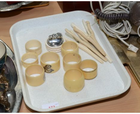 A quantity of white metal mounted ivory and bone napkin rings, four bone glove stretchers and a table lighter