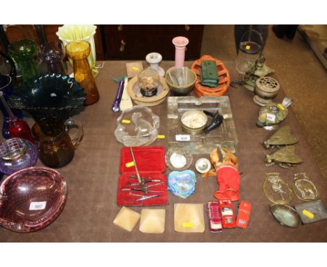 A large glass ashtray; a Mats Jonasson crystal ornament decorated with otter; candle stick etc