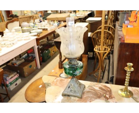A Victorian oil lamp with cast base, green tinted reservoir and etched shade