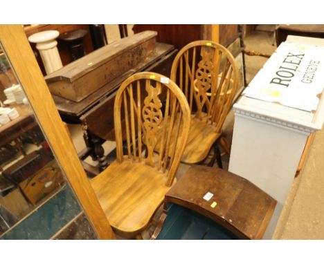A pair of stick and wheel back chairs