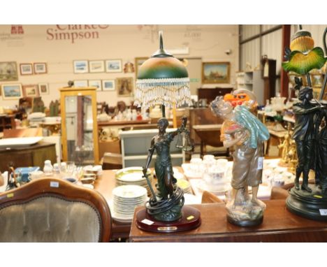 An art deco style bronzed figural table lamp with beaded shade